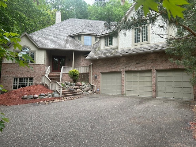 6323 Timber Trl, Edina, MN 55439 - view of front of property featuring brick siding, a chimney, driveway, a garage, and stucco siding
