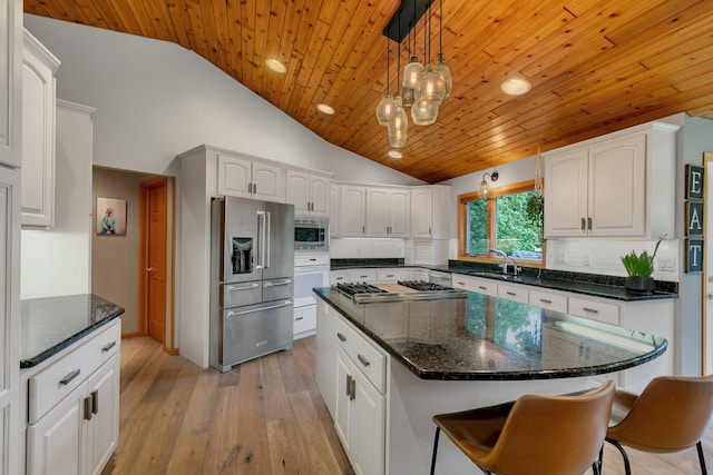 8081 45th Ave SW, Raymond, MN 56282 - kitchen with stainless steel appliances, vaulted ceiling, wood ceiling, white cabinetry, and hanging light fixtures