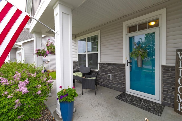 4745 Copper Cir, Woodbury, MN 55129 - doorway to property featuring covered porch and stone siding