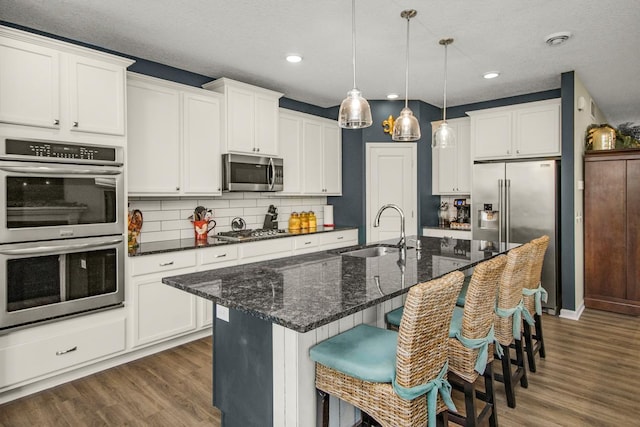 4745 Copper Cir, Woodbury, MN 55129 - kitchen featuring stainless steel appliances, dark wood finished floors, backsplash, decorative light fixtures, and recessed lighting