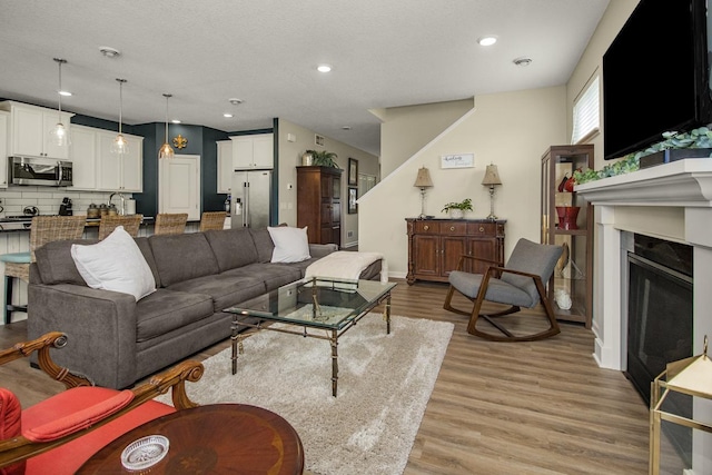 4745 Copper Cir, Woodbury, MN 55129 - living room with light wood-style flooring, a fireplace, and recessed lighting