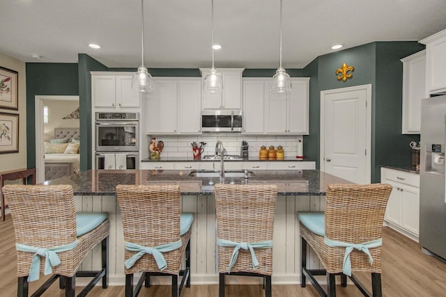 4745 Copper Cir, Woodbury, MN 55129 - kitchen featuring stainless steel appliances, light wood-type flooring, decorative backsplash, and recessed lighting