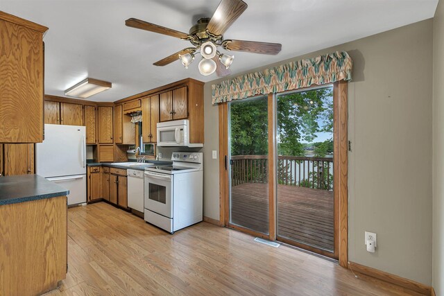 16736 County Road 49, Cold Spring, MN 56320 - kitchen with white appliances, dark countertops, light wood-style floors, and a sink