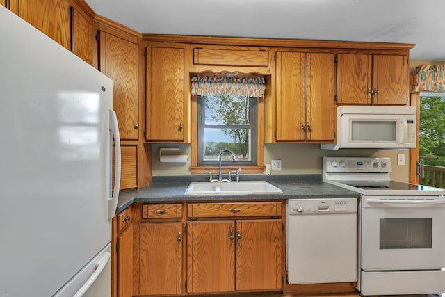 16736 County Road 49, Cold Spring, MN 56320 - kitchen featuring white appliances, a sink, brown cabinets, and dark countertops