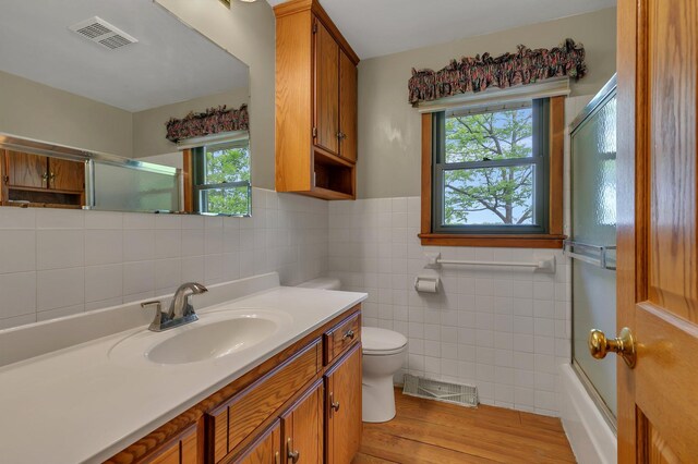 16736 County Road 49, Cold Spring, MN 56320 - full bath with tile walls, toilet, vanity, wood finished floors, and healthy amount of natural light