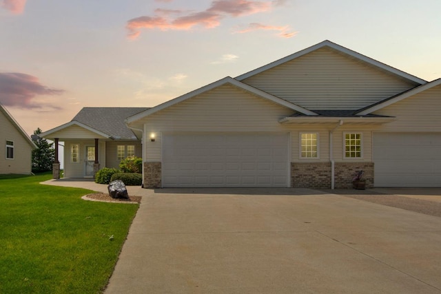 2475 Mossy Creek Dr NE, Owatonna, MN 55060 - view of front of house featuring an attached garage, a front yard, driveway, and brick siding