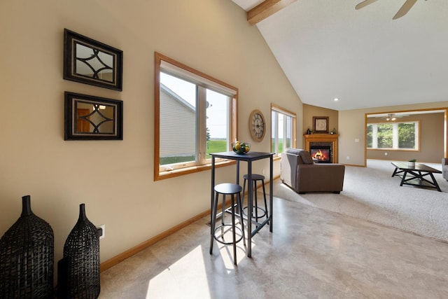 2475 Mossy Creek Dr NE, Owatonna, MN 55060 - carpeted dining room featuring a ceiling fan, a glass covered fireplace, beamed ceiling, and high vaulted ceiling