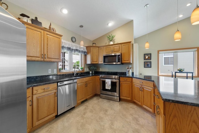 2475 Mossy Creek Dr NE, Owatonna, MN 55060 - kitchen with stainless steel appliances, lofted ceiling, a peninsula, pendant lighting, and brown cabinetry