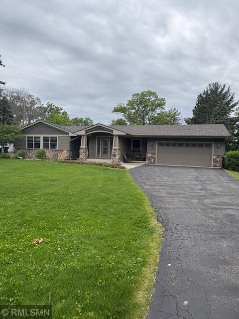 8456 Mississippi Blvd NW, Coon Rapids, MN 55433 - view of front of home with an attached garage, stone siding, driveway, and a front yard