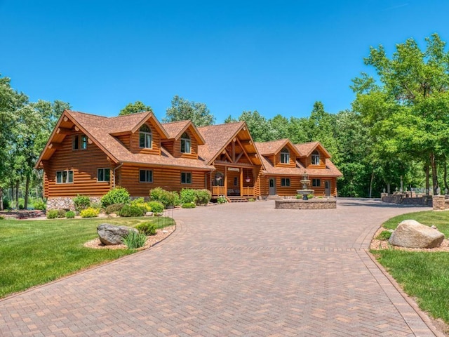 10719 Lumberjack Rd NW, Alaska Twp, MN 56667 - cabin with log siding, curved driveway, and a front yard