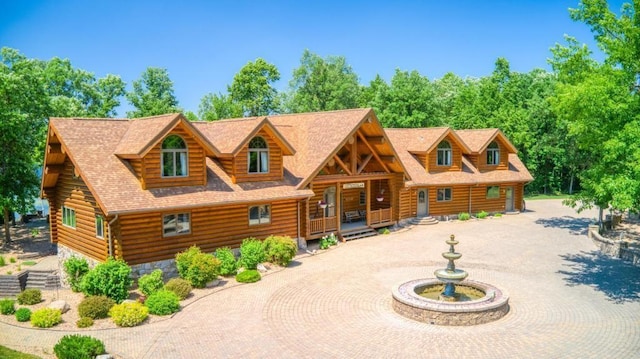 10719 Lumberjack Rd NW, Alaska Twp, MN 56667 - log-style house featuring log exterior, covered porch, a shingled roof, and curved driveway