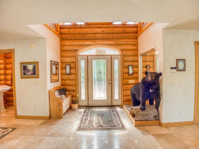 10719 Lumberjack Rd NW, Alaska Twp, MN 56667 - tiled foyer entrance featuring log walls, baseboards, and a towering ceiling