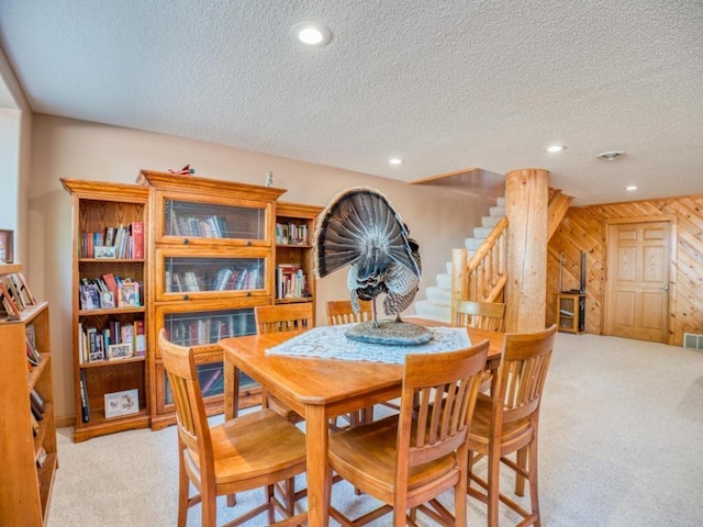 10719 Lumberjack Rd NW, Alaska Twp, MN 56667 - dining area with a textured ceiling, carpet flooring, recessed lighting, wood walls, and stairway