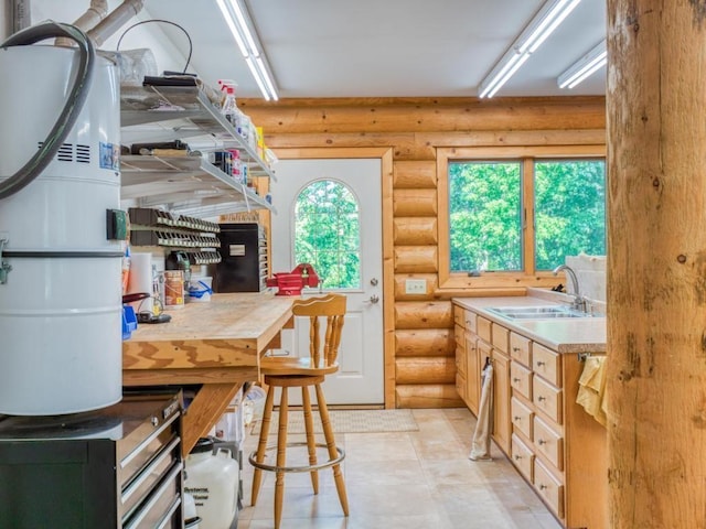 10719 Lumberjack Rd NW, Alaska Twp, MN 56667 - kitchen featuring a sink, log walls, and light countertops