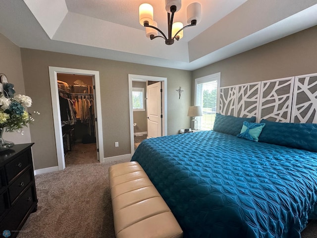 879 Longview Dr, Detroit Lakes, MN 56501 - bedroom featuring a chandelier, a tray ceiling, carpet, a walk in closet, and baseboards