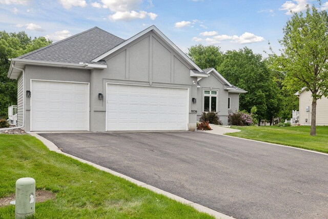 9536 Windflower Pl, Champlin, MN 55316 - view of front of house with a garage, asphalt driveway, a shingled roof, and a front lawn