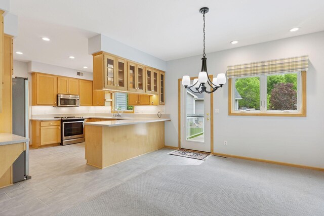 9536 Windflower Pl, Champlin, MN 55316 - kitchen featuring appliances with stainless steel finishes, a peninsula, a chandelier, glass insert cabinets, and light countertops