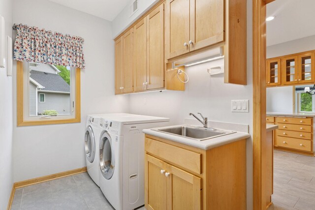 9536 Windflower Pl, Champlin, MN 55316 - laundry room featuring washing machine and dryer, healthy amount of natural light, cabinet space, and baseboards