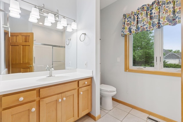 9536 Windflower Pl, Champlin, MN 55316 - full bathroom featuring a stall shower, tile patterned floors, baseboards, vanity, and toilet