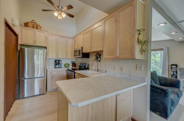 1970 Saint Croix Trl N, West Lakeland Twp, MN 55082 - kitchen featuring appliances with stainless steel finishes, a sink, light brown cabinets, ceiling fan, and a towering ceiling