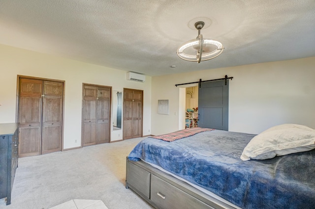 1970 Saint Croix Trl N, West Lakeland Twp, MN 55082 - bedroom with a barn door, a textured ceiling, light carpet, an AC wall unit, and two closets