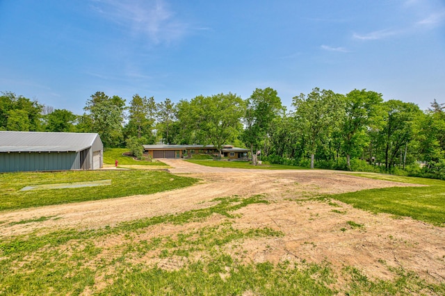 1970 Saint Croix Trl N, West Lakeland Twp, MN 55082 - view of grassy yard with a pole building, driveway, an outdoor structure, view of scattered trees, and a garage