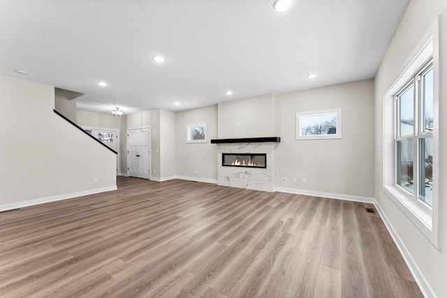 1700 Misty Cir, Buffalo, MN 55313 - unfurnished living room featuring wood finished floors, healthy amount of natural light, a premium fireplace, baseboards, and recessed lighting