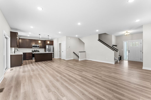 1700 Misty Cir, Buffalo, MN 55313 - unfurnished living room featuring light wood-type flooring, baseboards, recessed lighting, a sink, and stairway