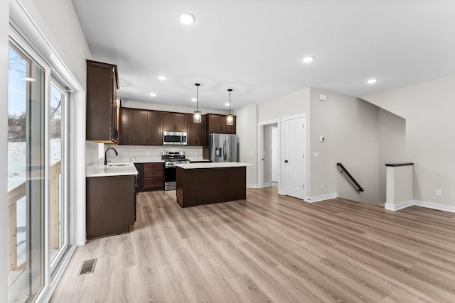 1700 Misty Cir, Buffalo, MN 55313 - kitchen with appliances with stainless steel finishes, dark brown cabinetry, a sink, a center island, and recessed lighting