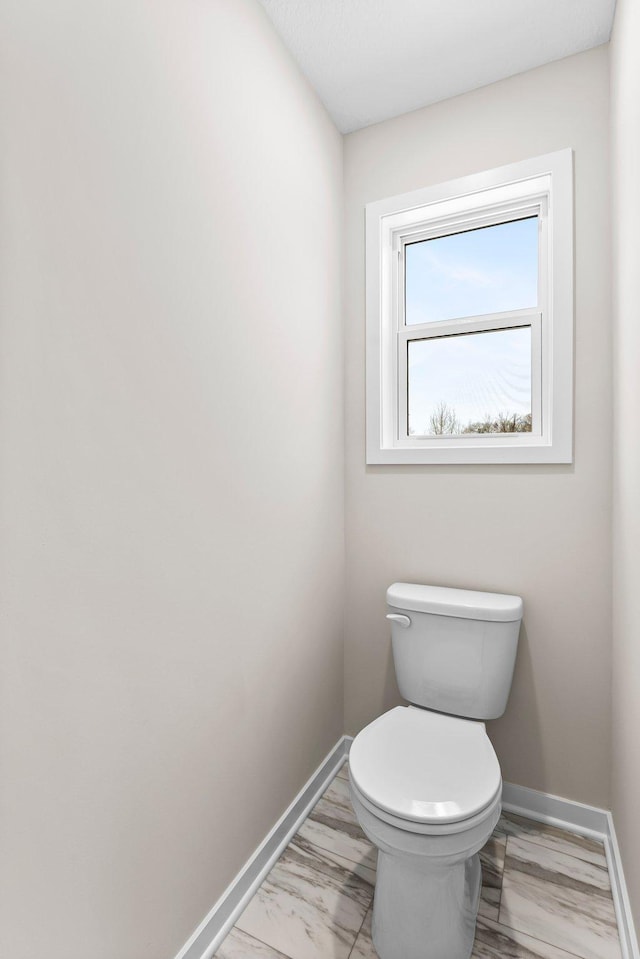 1700 Misty Cir, Buffalo, MN 55313 - bathroom featuring marble look tile flooring, baseboards, and toilet