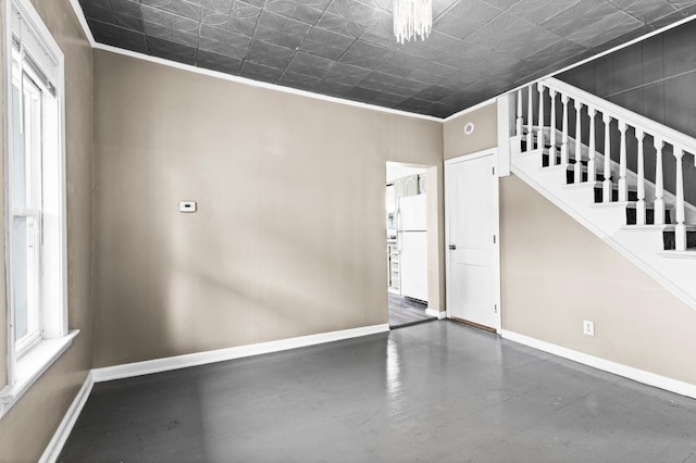 319 60th Ave W, Duluth, MN 55807 - spare room with baseboards, crown molding, finished concrete floors, an ornate ceiling, and plenty of natural light