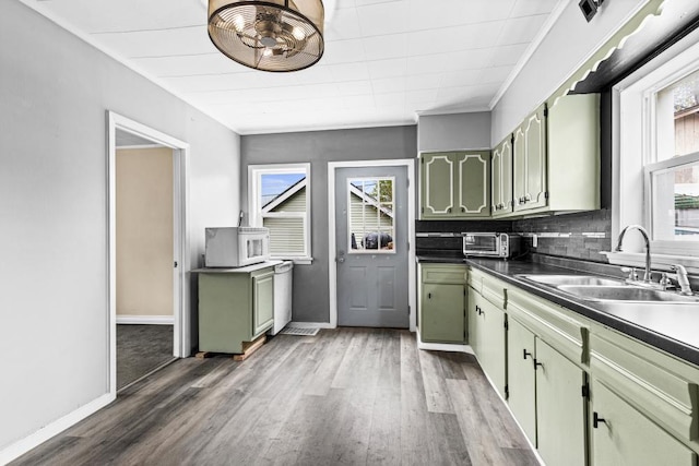 319 60th Ave W, Duluth, MN 55807 - kitchen featuring a sink, green cabinets, light wood finished floors, dark countertops, and crown molding