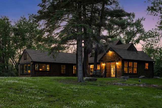 605 Stubbs Bay Rd, Orono, MN 55356 - back of property at dusk featuring a lawn and roof with shingles