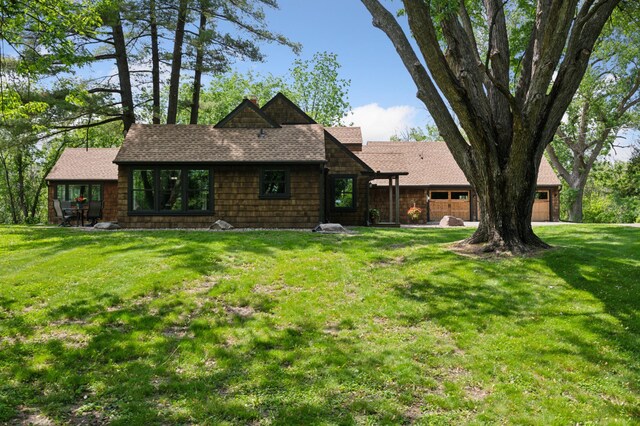 605 Stubbs Bay Rd, Orono, MN 55356 - back of house featuring a garage, a lawn, and roof with shingles