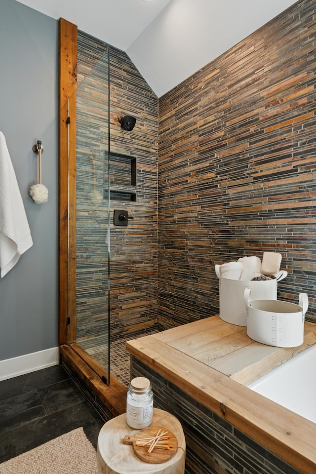605 Stubbs Bay Rd, Orono, MN 55356 - bathroom featuring a shower stall, baseboards, and vaulted ceiling