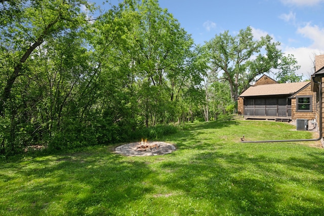 605 Stubbs Bay Rd, Orono, MN 55356 - view of grassy yard featuring an outdoor fire pit, a sunroom, and central air condition unit