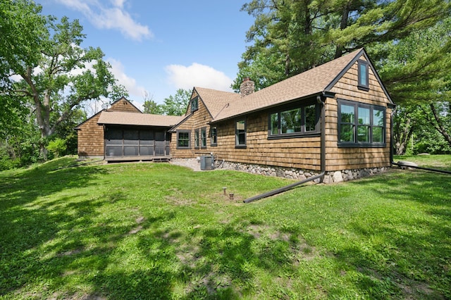 605 Stubbs Bay Rd, Orono, MN 55356 - back of property featuring a chimney, a sunroom, central AC, a shingled roof, and a yard