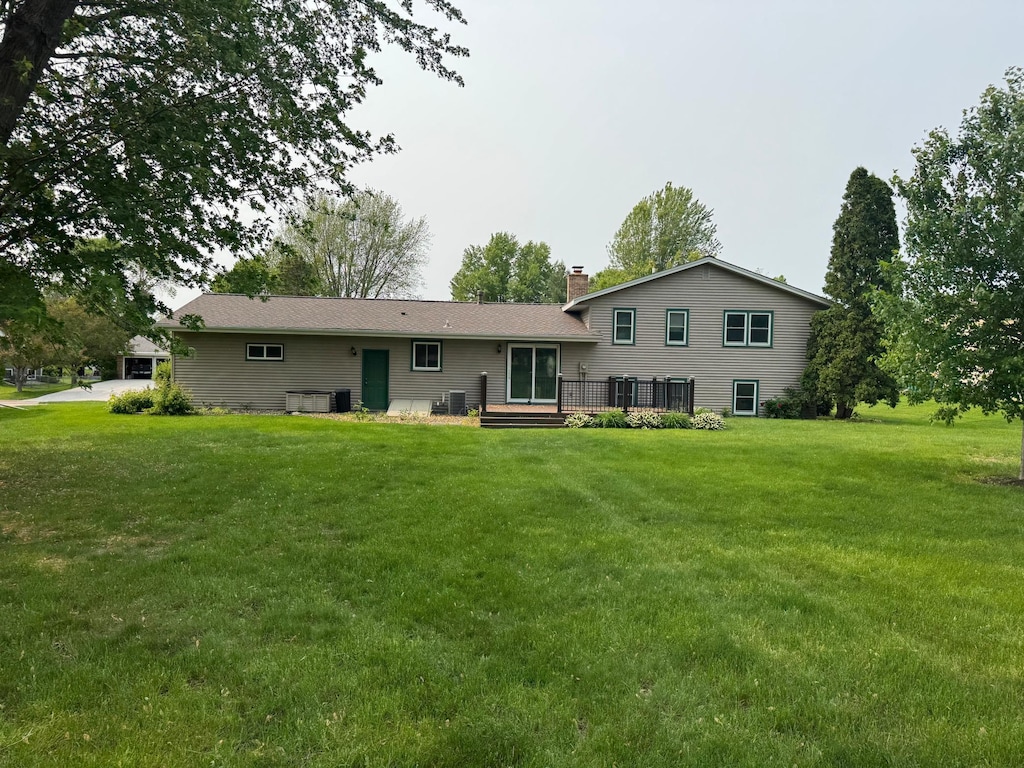 155 Outer Dr, Le Sueur, MN 56058 - rear view of property with a wooden deck, a lawn, a chimney, and cooling unit