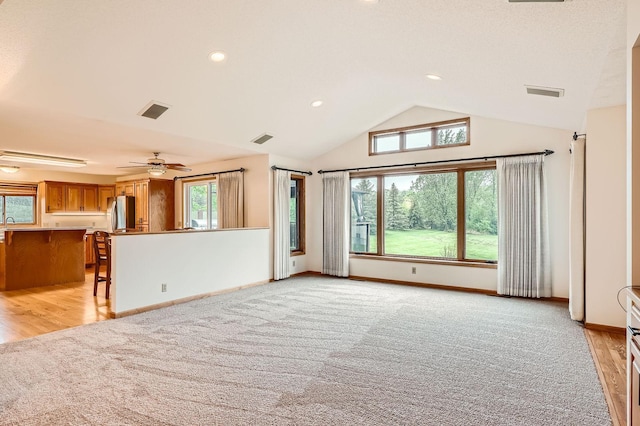 3544 166th Ln NW, Andover, MN 55304 - unfurnished living room featuring vaulted ceiling, baseboards, light wood-type flooring, light colored carpet, and a ceiling fan
