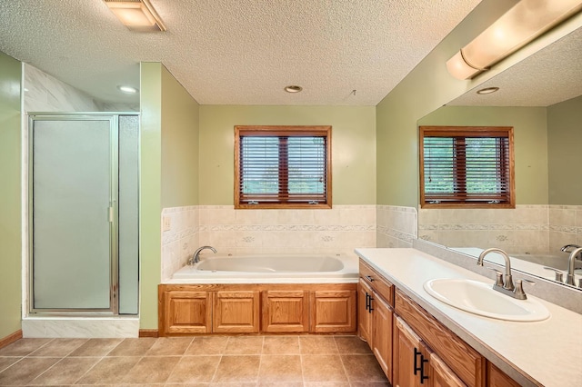 3544 166th Ln NW, Andover, MN 55304 - full bathroom with tile patterned flooring, a stall shower, a garden tub, vanity, and a textured ceiling