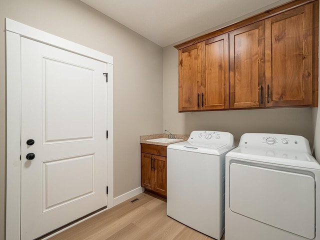 20713 Tamarack St NW, Oak Grove, MN 55011 - laundry room featuring cabinet space, separate washer and dryer, light wood-type flooring, and baseboards