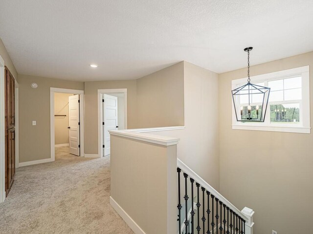 20713 Tamarack St NW, Oak Grove, MN 55011 - corridor with a chandelier, an upstairs landing, light carpet, baseboards, and recessed lighting