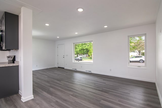 619 Aspen Ave S, Amery, WI 54001 - unfurnished living room with dark wood-type flooring, baseboards, and recessed lighting