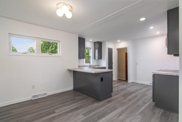 619 Aspen Ave S, Amery, WI 54001 - kitchen with light countertops, dark wood finished floors, a peninsula, baseboards, and recessed lighting