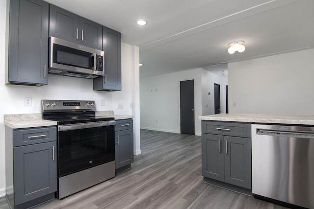 619 Aspen Ave S, Amery, WI 54001 - kitchen featuring stainless steel appliances, light countertops, light wood-type flooring, gray cabinets, and recessed lighting