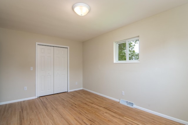 619 Aspen Ave S, Amery, WI 54001 - unfurnished bedroom featuring light wood-style floors, baseboards, and a closet