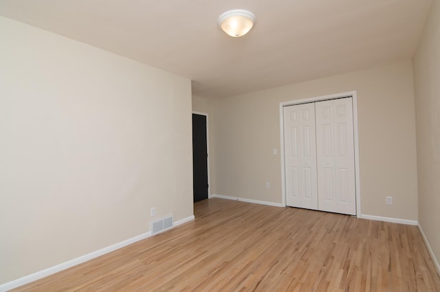 619 Aspen Ave S, Amery, WI 54001 - unfurnished bedroom featuring light wood-style floors, a closet, and baseboards