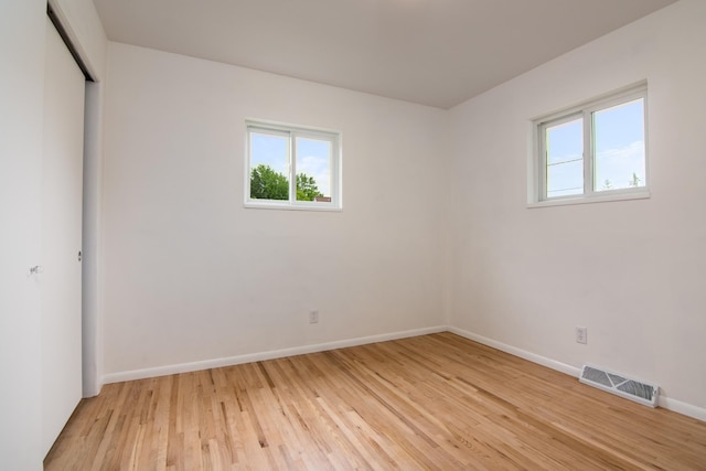 619 Aspen Ave S, Amery, WI 54001 - unfurnished bedroom featuring multiple windows, light wood-type flooring, baseboards, and a closet