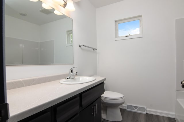 619 Aspen Ave S, Amery, WI 54001 - bathroom with wood finished floors, vanity, toilet, baseboards, and healthy amount of natural light