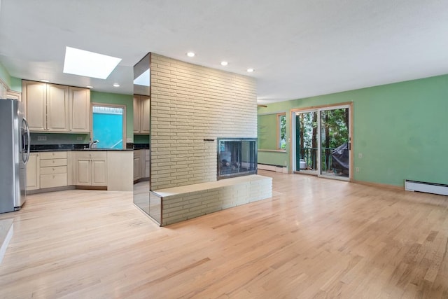 364 Owasso Blvd N, Shoreview, MN 55126 - unfurnished living room with baseboard heating, a skylight, light wood-type flooring, recessed lighting, and a fireplace
